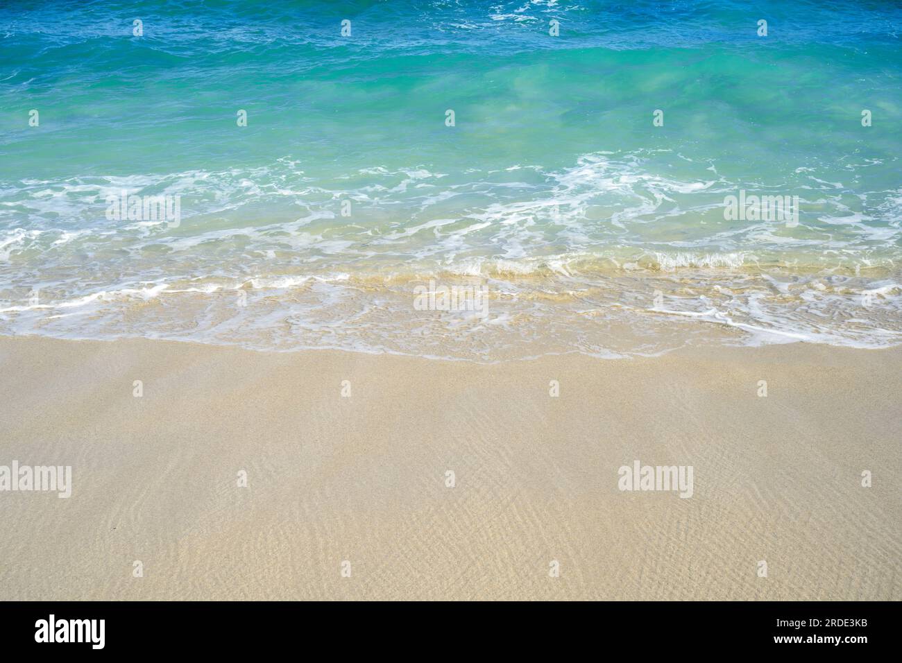 Sandy beach with the blue ocean and blue sky background Stock Photo - Alamy