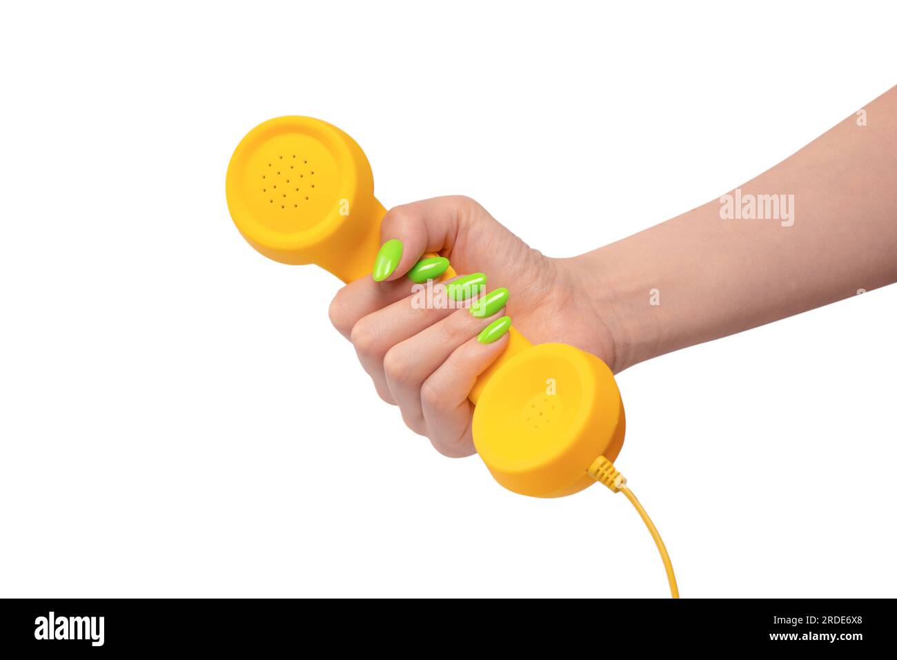 Yellow handset in woman hand with green nails isolated on a white background. Copy space. Stock Photo