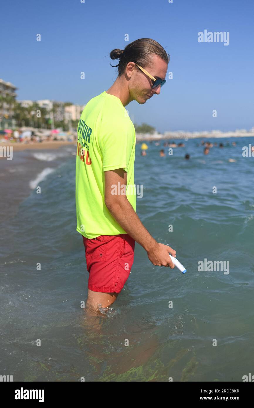 Cannes, France. 20th July, 2023. A lifeguard checks water's temperature