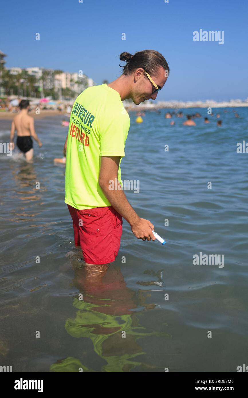 Cannes, France. 20th July, 2023. A lifeguard checks water's temperature