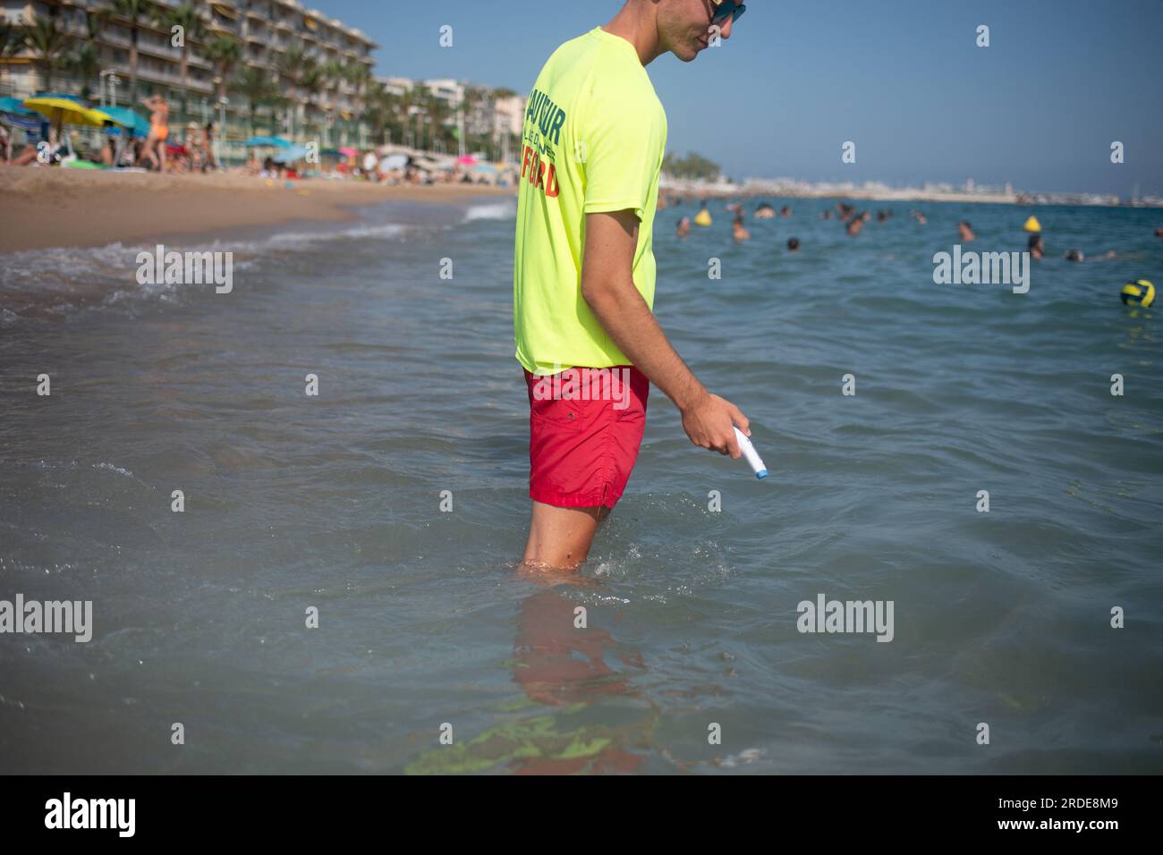 Cannes, France. 20th July, 2023. A lifeguard checks water's temperature