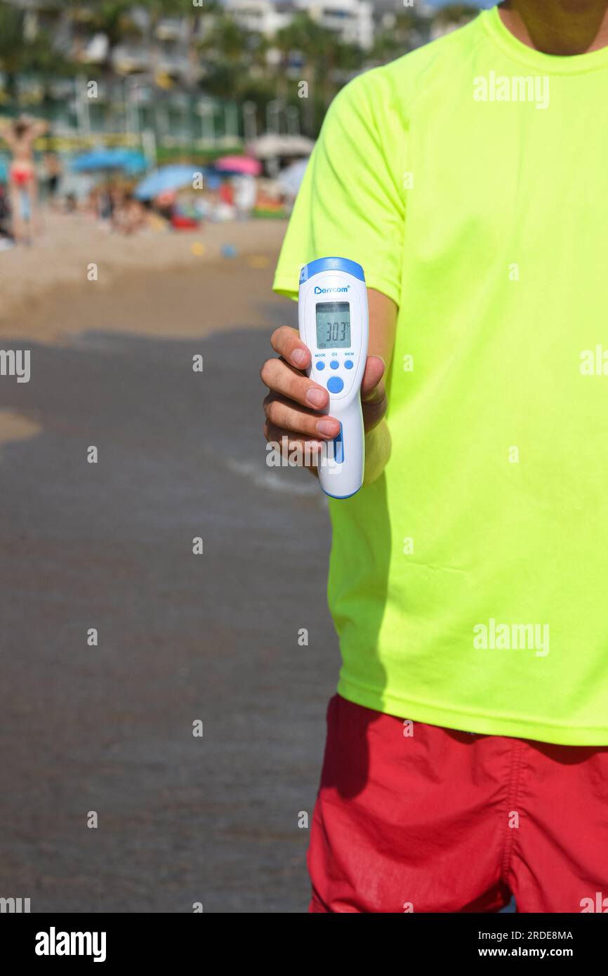 Cannes, France. 20th July, 2023. A lifeguard checks water's temperature