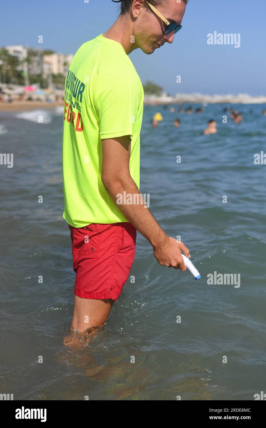 Cannes, France. 20th July, 2023. A lifeguard checks water's temperature