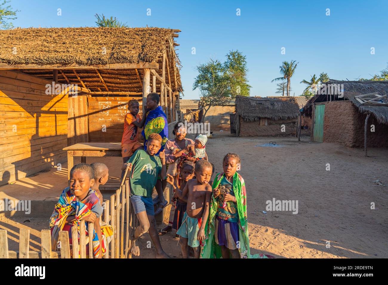 Morondava, Madagascar - May 31.2023: Malagasy family with them children at sunrise, background a wood hut Stock Photo
