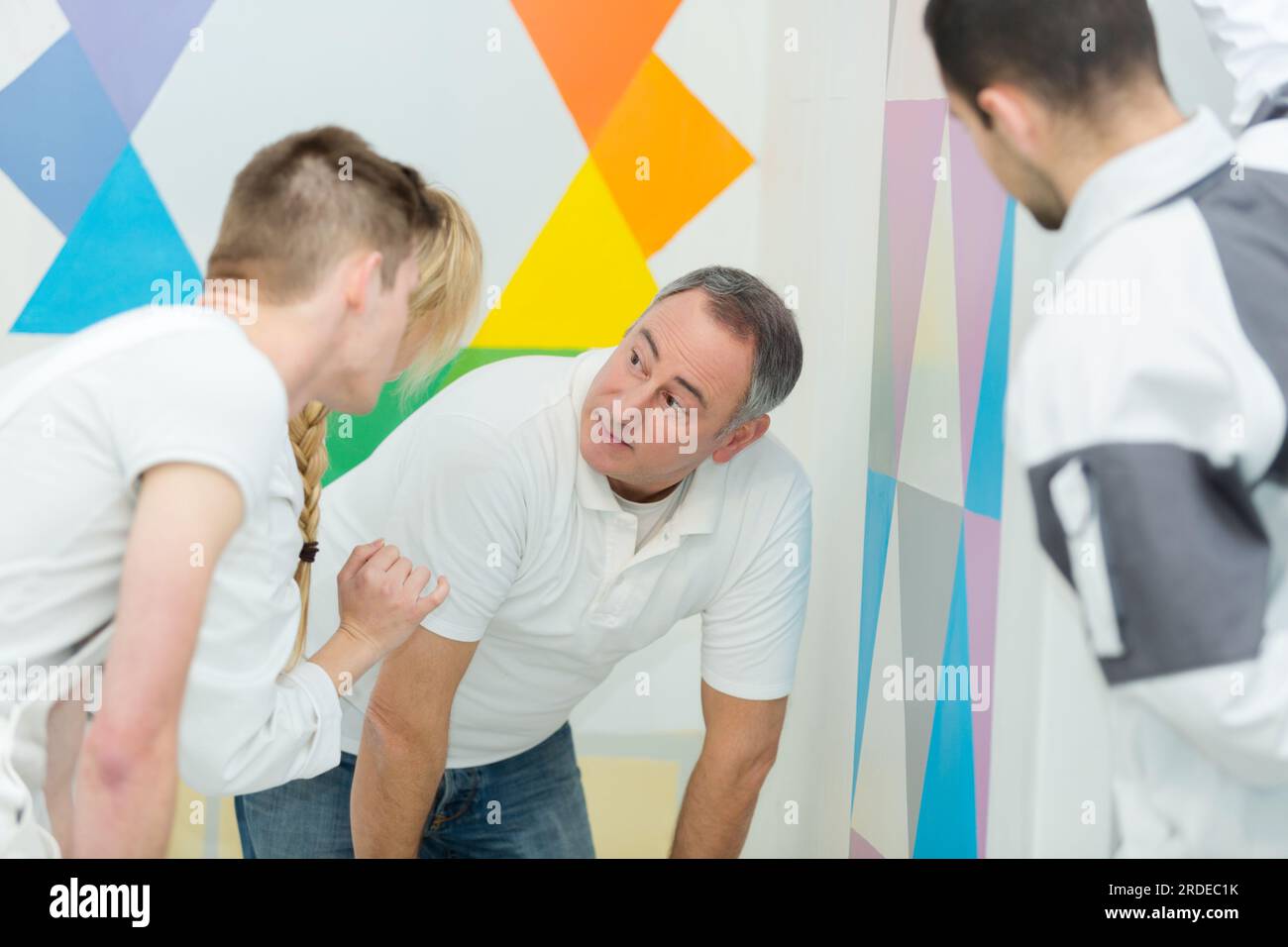 tutor inspecting students work on decorating course Stock Photo