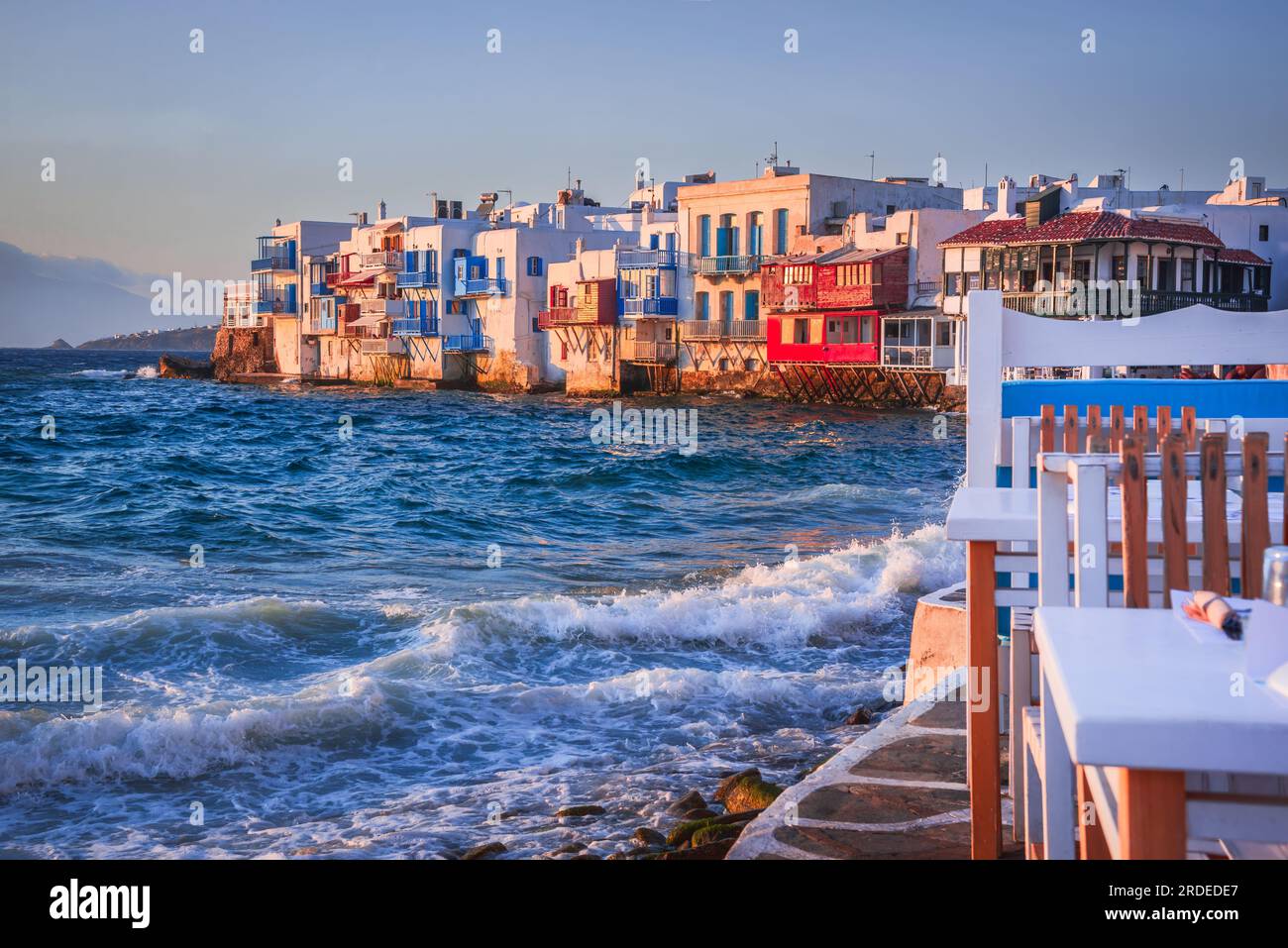 Little Venice in Mykonos is a charming neighborhood where colorful houses stand at the water's edge, offering breathtaking views of the Aegean Sea and Stock Photo