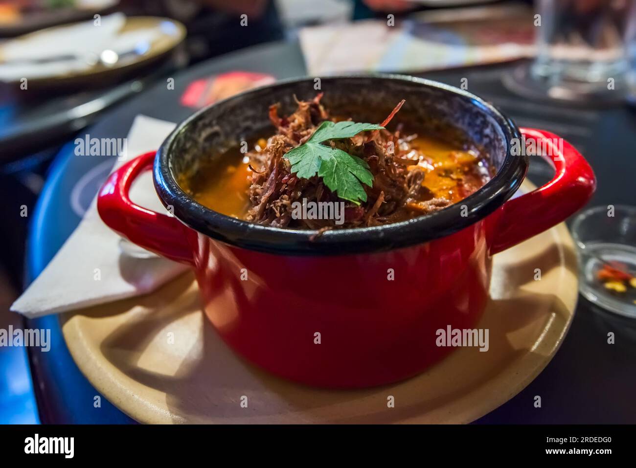 Gulyas, traditional Hungarian dish, hearty stew made with beef or pork, onions, paprika, tomatoes, and various spices. Local restaurant in old Buda. Stock Photo