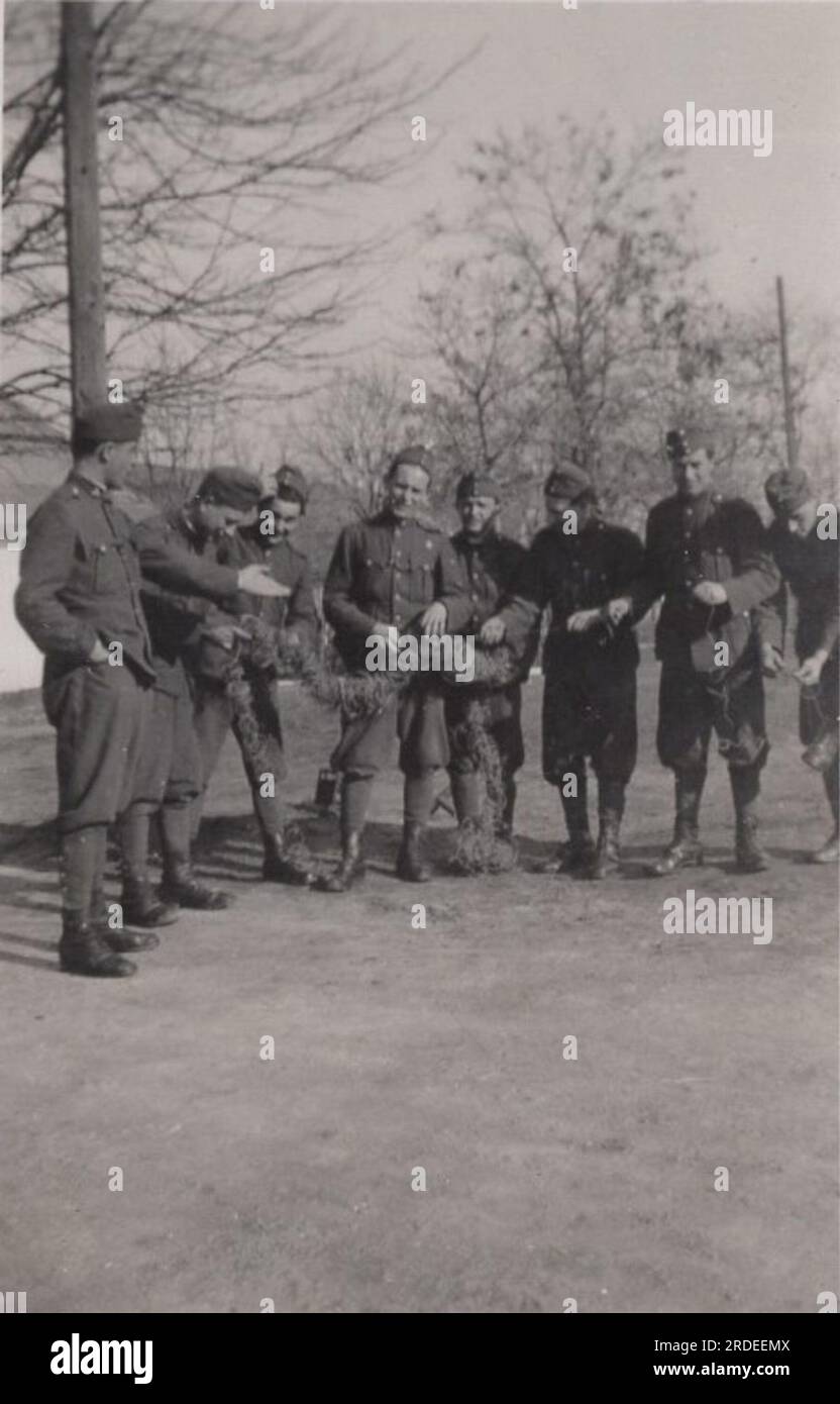 vintage funny military life moment from the second world war ( ww2) one unit stand togedher for the camera in them uniform. May be it is a happy birthday photo about the soldier who is standing in the middle. Stock Photo