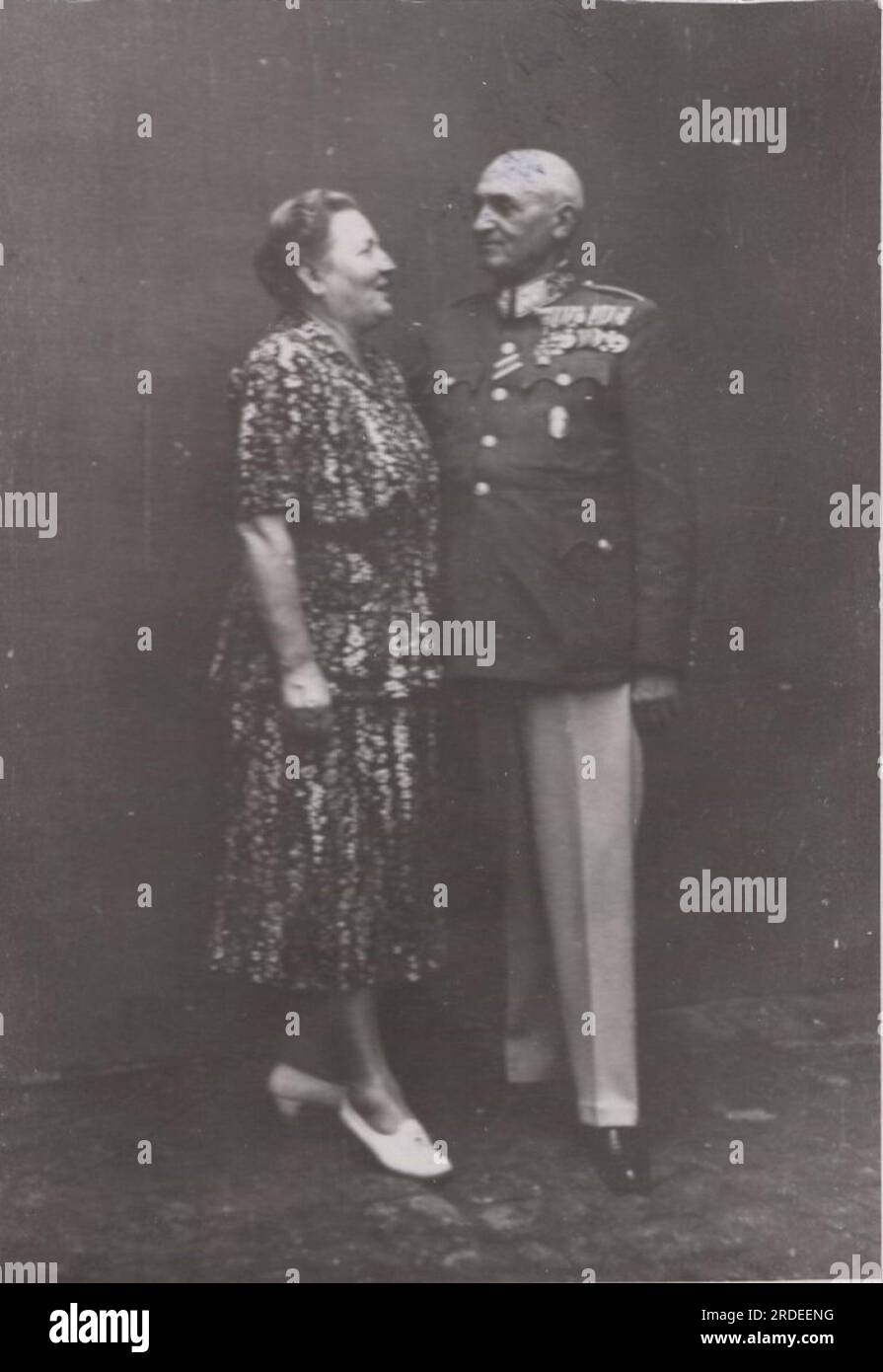 vintage family photo wife snd her loved hunband posing for the camera. The husband was high ranking soldier as he is wearing plenty of medal of honors on his ceremonial military uniform at the 1910s. Stock Photo