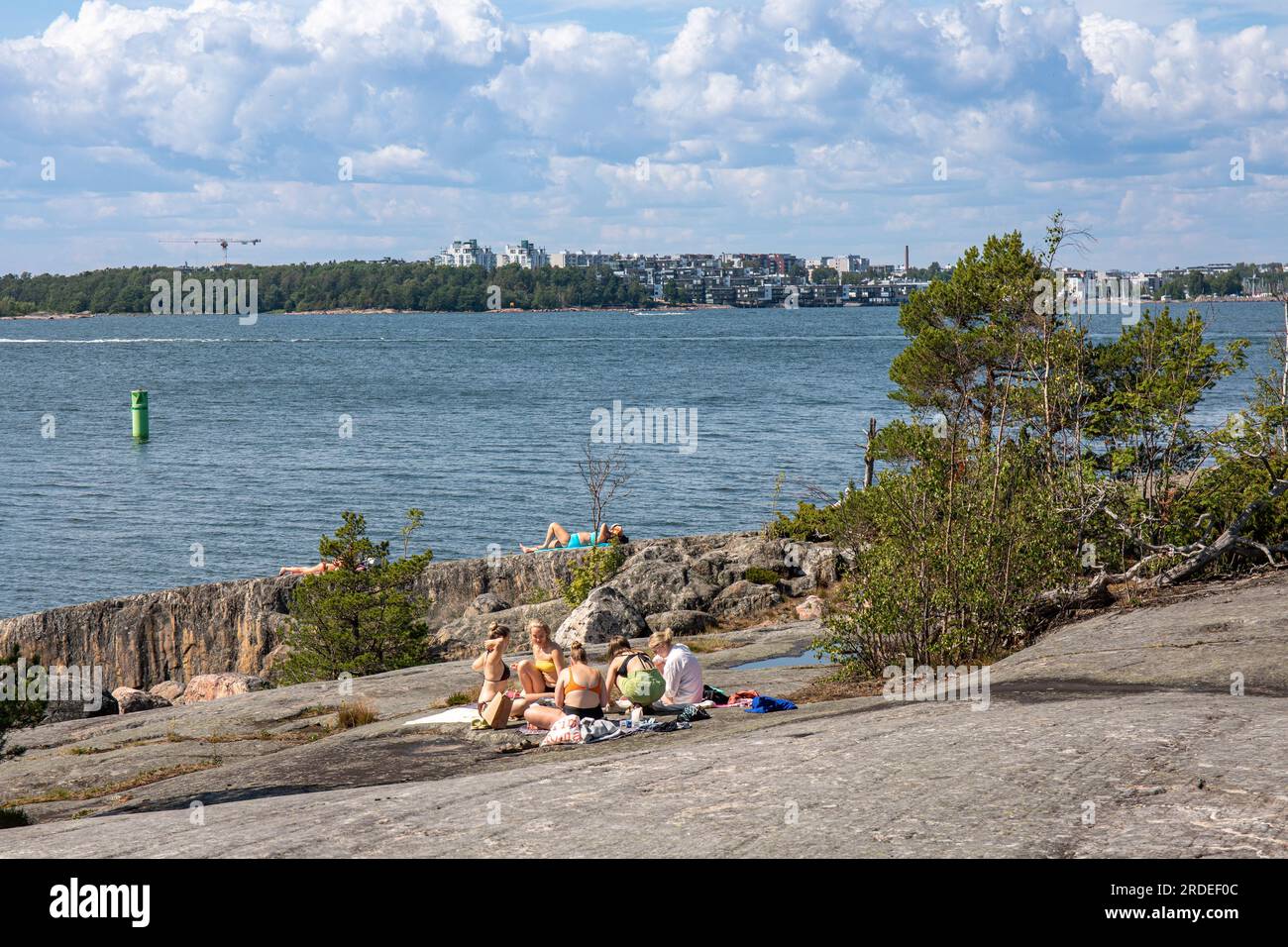 People sunbathing on Pihlajasaari Island cliffs in Helsinki, Finland Stock Photo