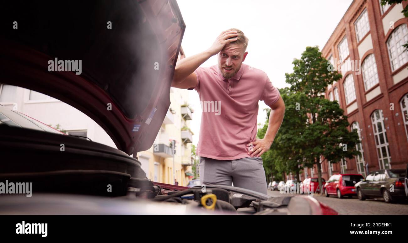 Broken Down Car. Frustrated Man Looking At Smoke Stock Photo