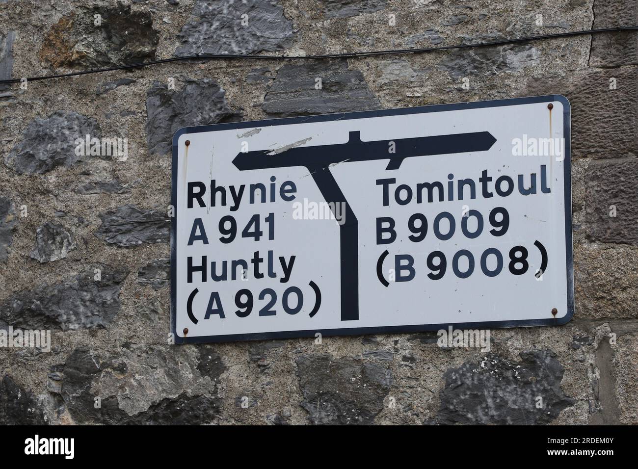 Road sign for Rhynie and Tomintoul on wall Dufftown Scotland July 2023 ...