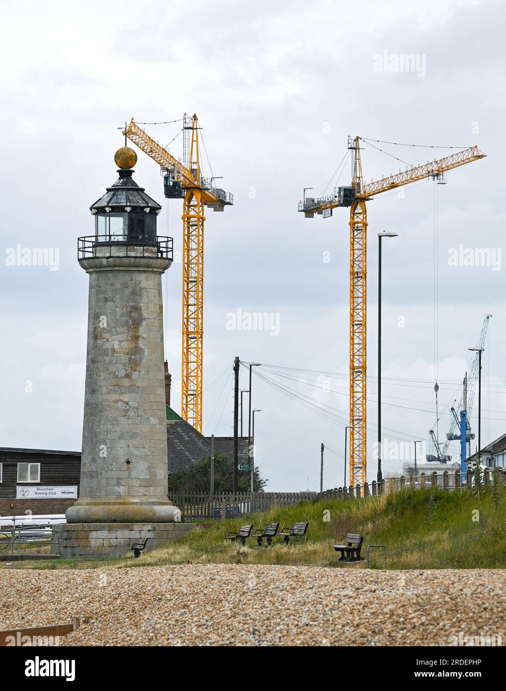 Shoreham Lighthouse with cranes from a nearby building construction site towering behind , Sussex , England , UK Stock Photo