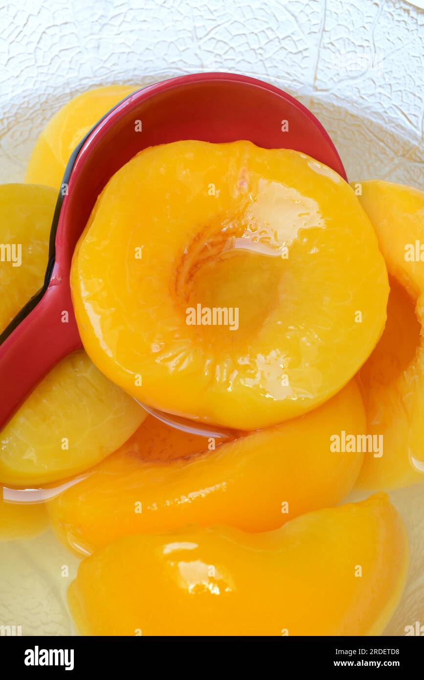 Peach, peach halves in syrup with ladle (Prunus persica Stock Photo Alamy