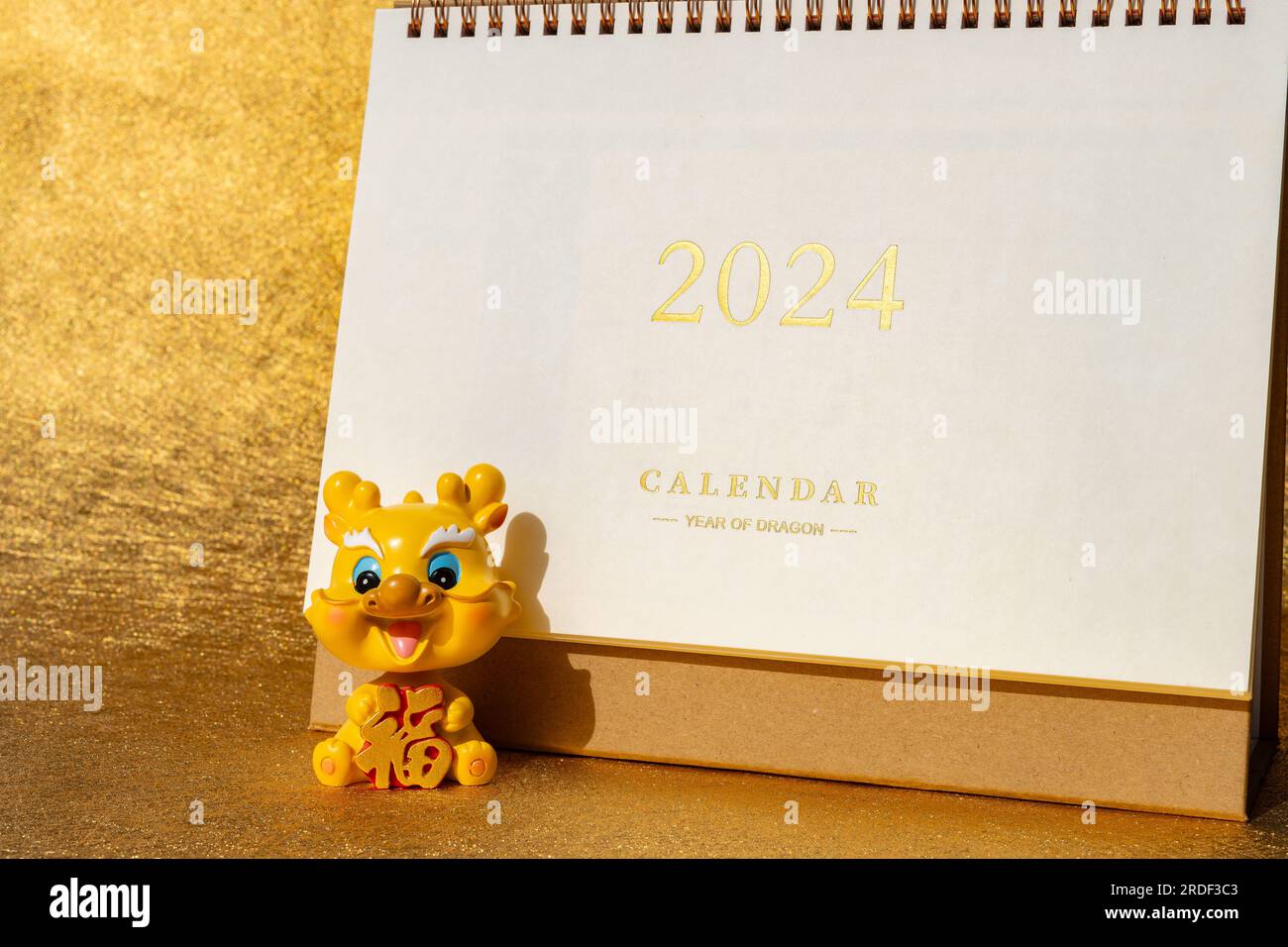 Year of Dragon mascot with a 2024 calendar at horizontal composition translation of the Chinese on the mascot is fortune no logo no trademark Stock Photo