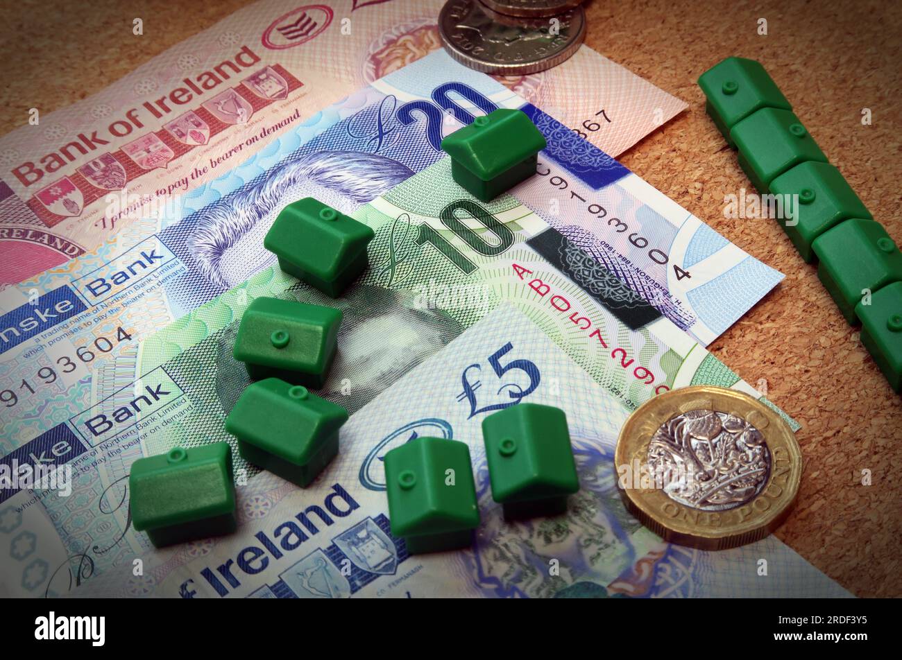 Accommodation costs ( buy or rent) in Northern Ireland, Sterling notes, coins, Monopoly houses Stock Photo
