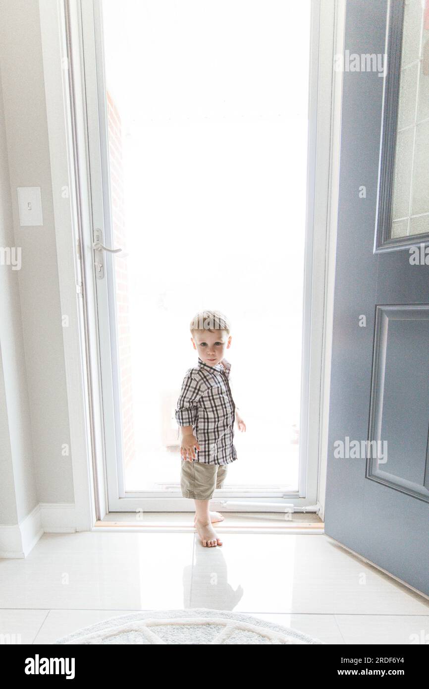 Toddler Boy in front of Bright Light from Door Stock Photo