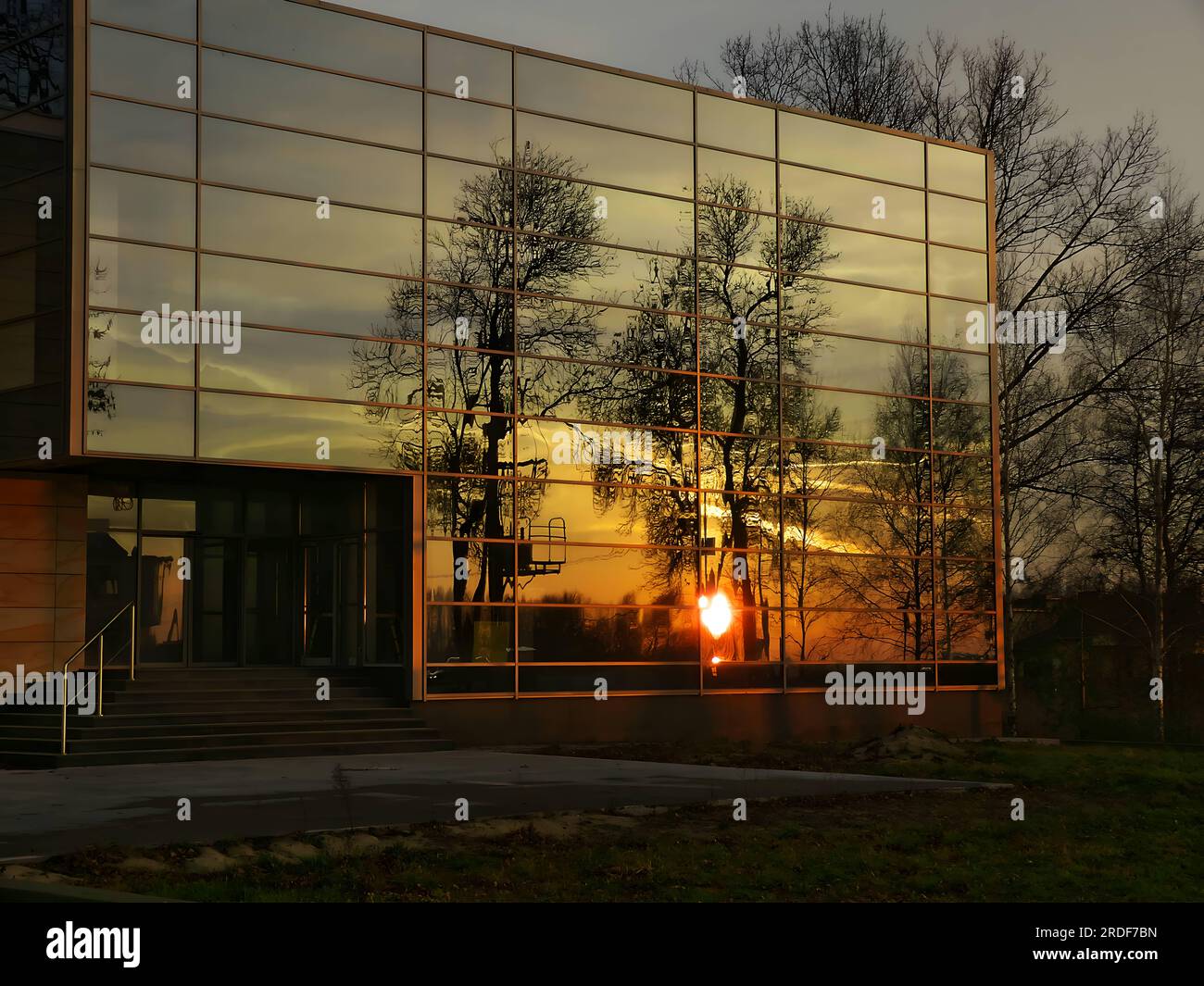Mirroring the sunset and trees in the windows of the building. Stock Photo