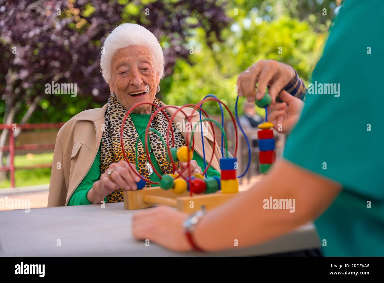 Hand of an elderly woman in the garden of a nursing home or retirement home playing with games to improve the mobility of the hands smiling Stock Photo