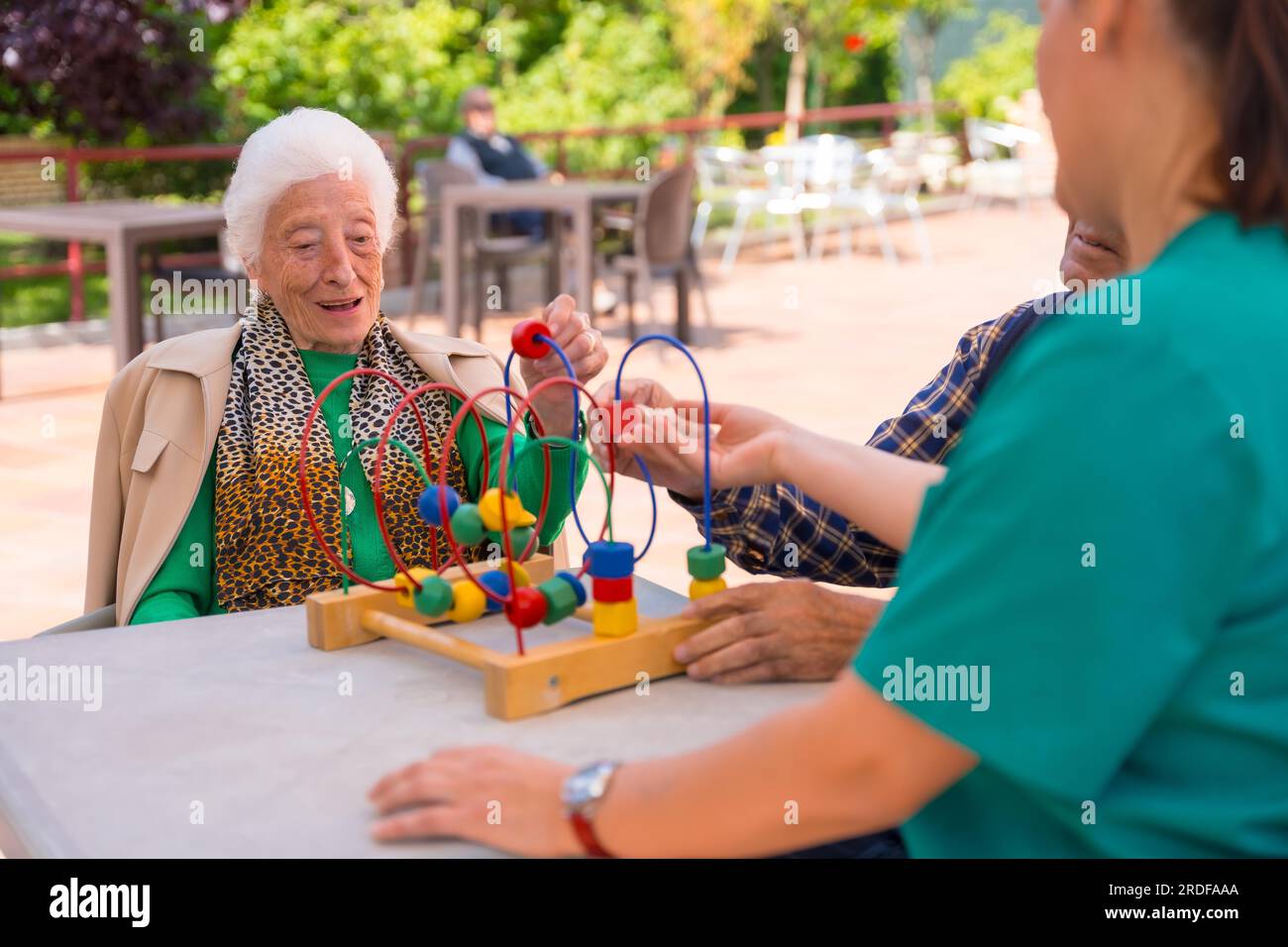 Two elderly people in the garden of a nursing home or retirement home playing with games to improve mobility Stock Photo
