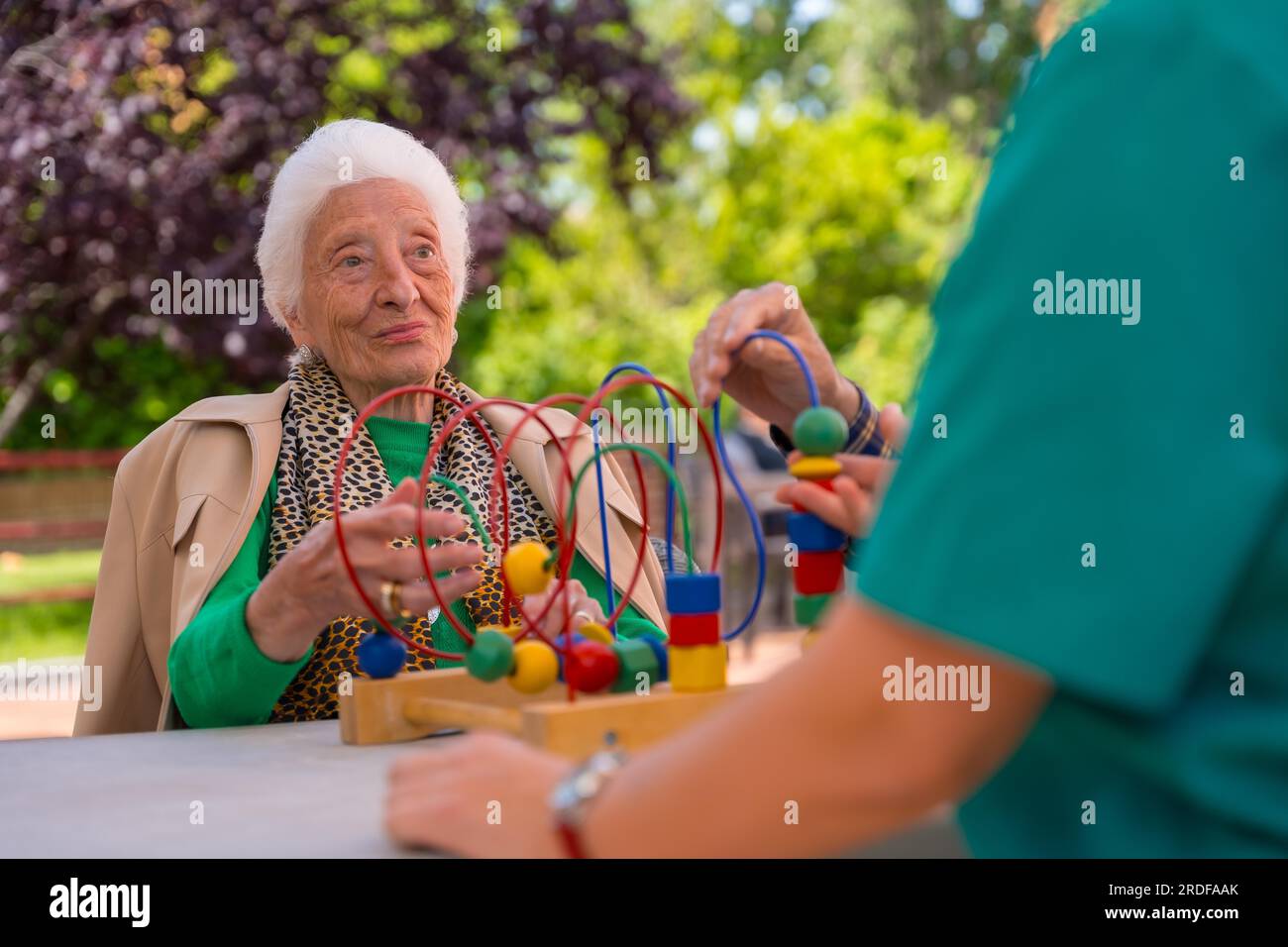 Hand of an elderly woman in the garden of a nursing home or retirement home playing with games to improve mobility Stock Photo