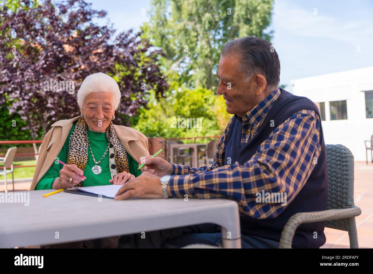 Two elderly people painting in the garden of a nursing home or retirement home, old man and old woman Stock Photo