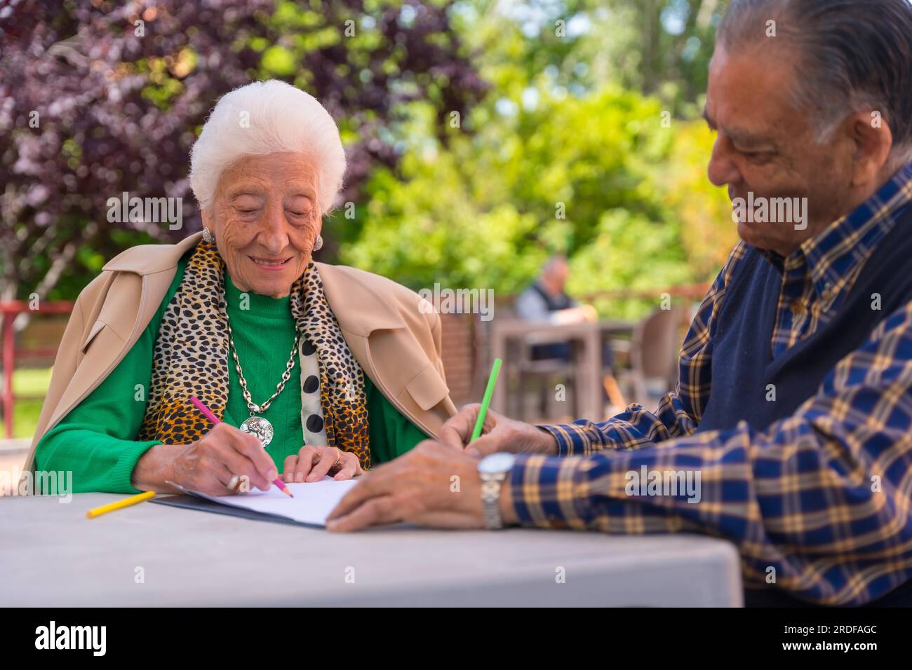 Two elderly people painting in the garden of a nursing home or retirement home Stock Photo