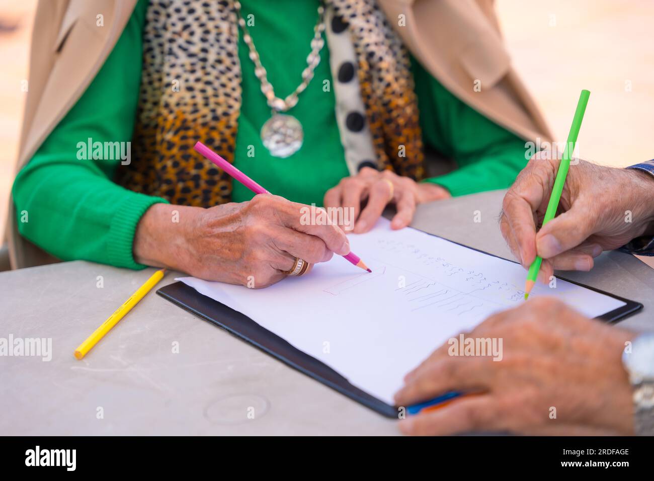 Two elderly people painting in the garden of a nursing home or retirement home Stock Photo