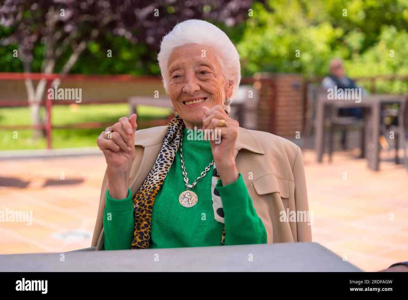 An elderly woman dancing in the garden of a nursing home or retirement home Stock Photo