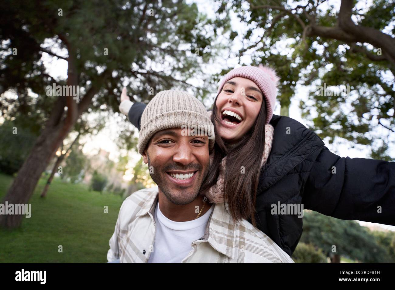 Crazy couple in love having fun taking a selfie piggyback in the nature ...