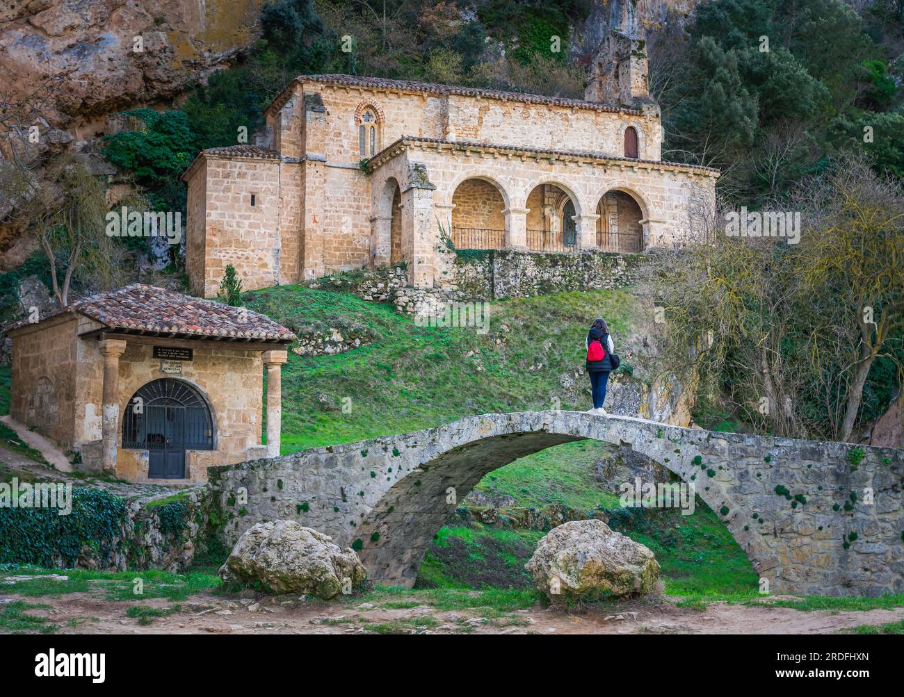 Image of a woman staring at the Hermitage of Santa María de la Hoz in the village of Tobera, located in the north of the province of Burgos (Spain) Stock Photo