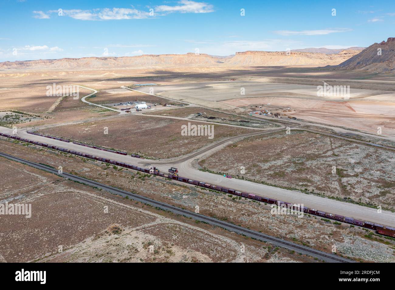 A reachstacker container handler removes containers of uranium tailings from a train at the UMTRA tailings deposition site in Utah. Stock Photo