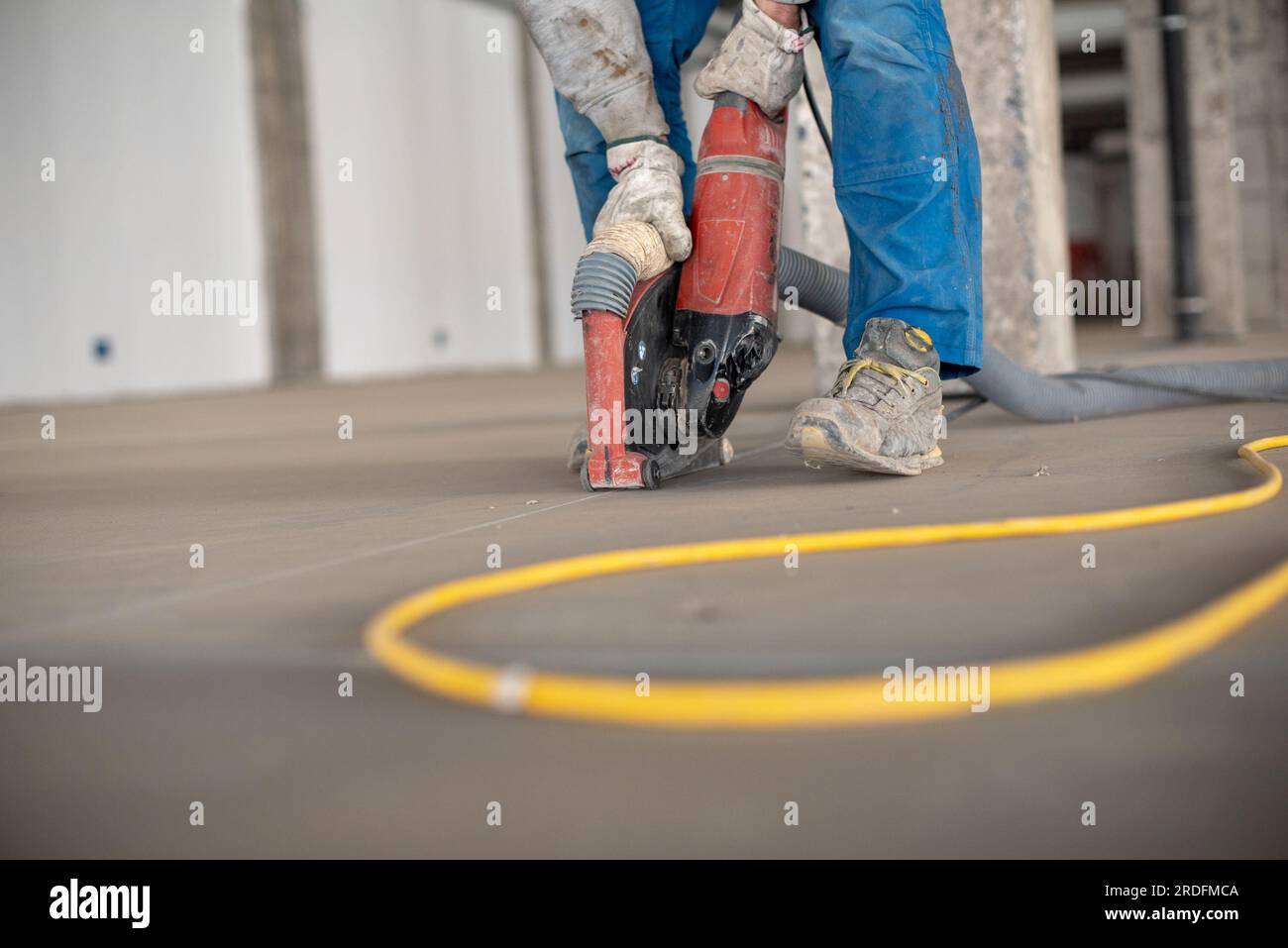 Crop site worker using concrete cutter Stock Photo
