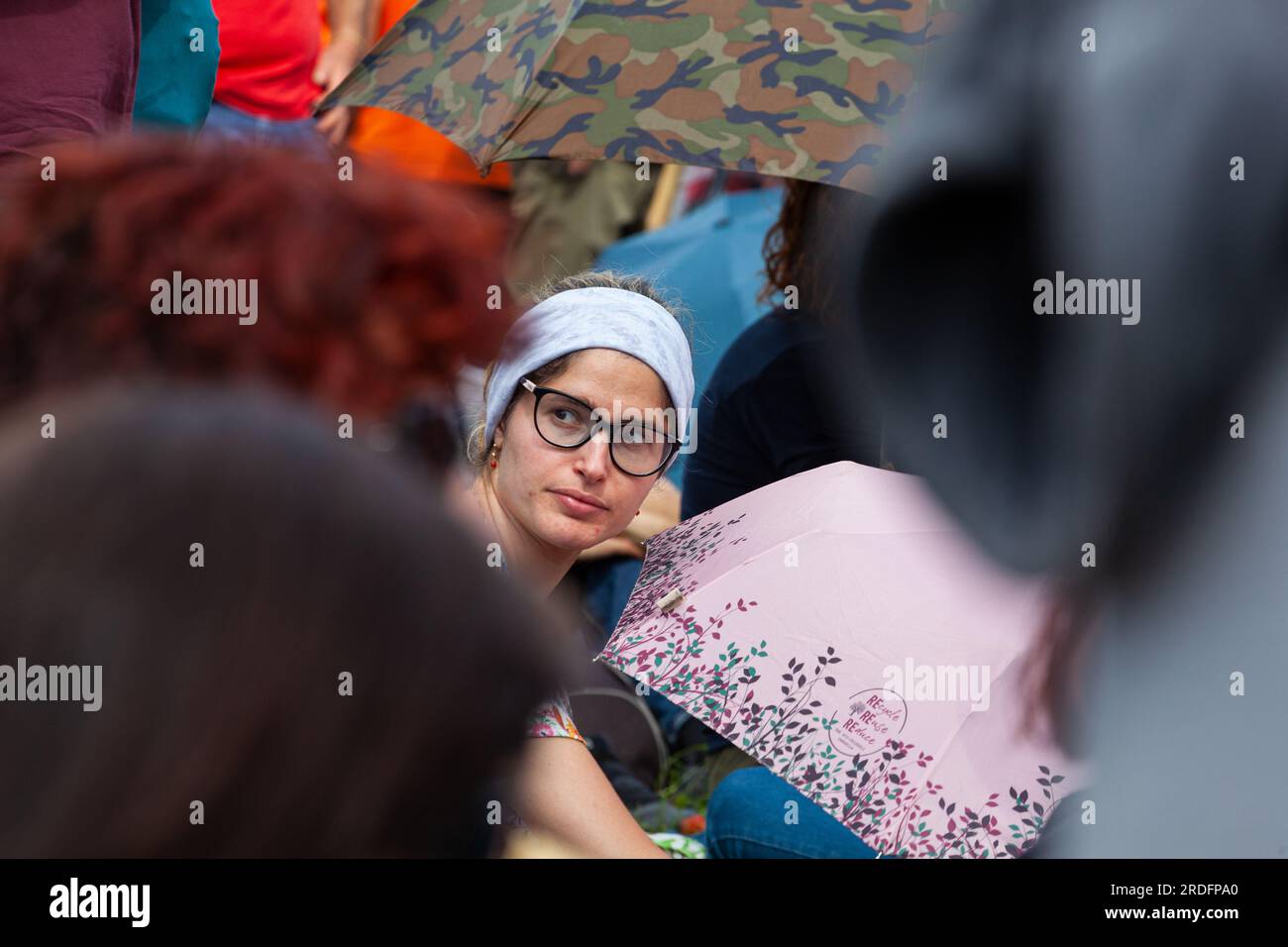 Gattatico, Reggio Emilia, Italy - April 25, 2023: Side view of girls friends watching concert in the park at open air Stock Photo