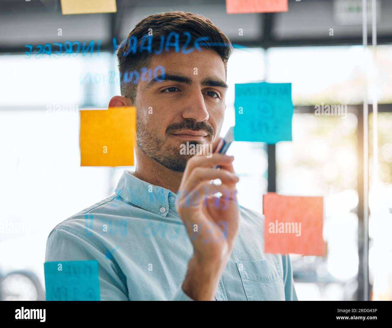 Business man brainstorming on glass, planning schedule and timeline of sticky note ideas. Face
