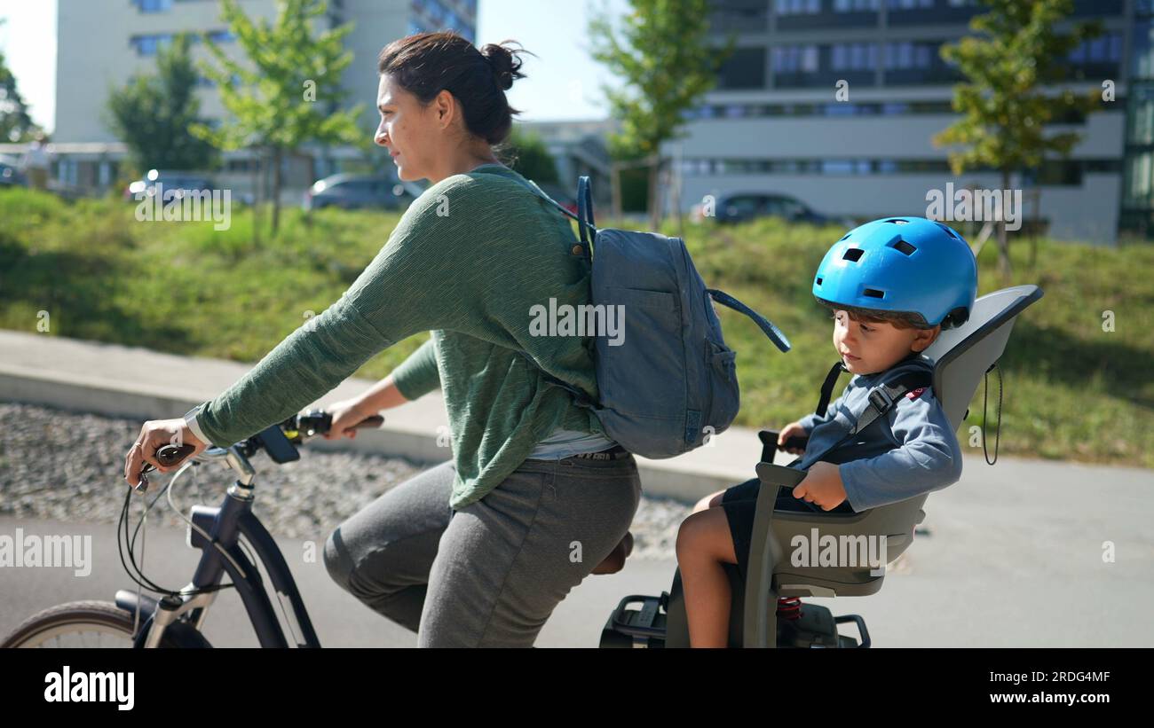 Kid in bicycle back seat riding with mom Stock Photo Alamy