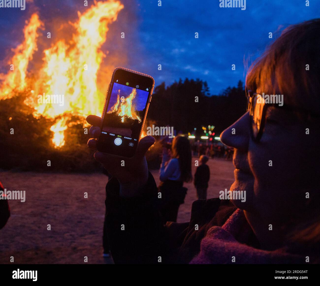 WALPURGIS BONFIRES in Sweden spectators take photos with their mobile phones  of the fire Stock Photo