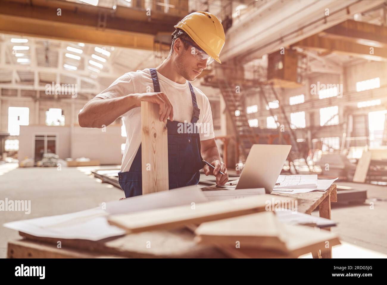Handsome man builder using notebook at construction site Stock Photo