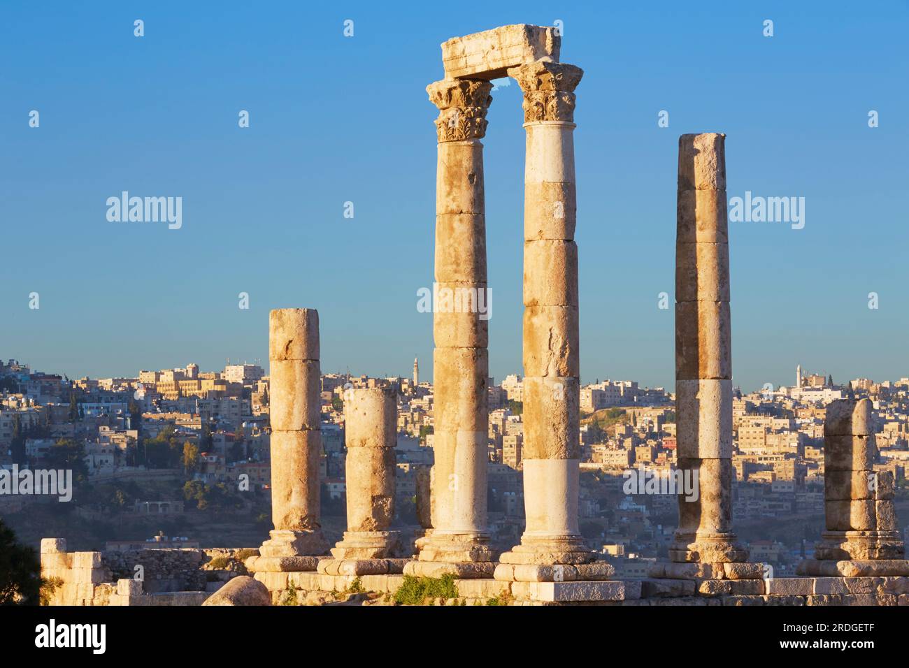 Columns of theTemple of Hercules in front of Amman city buildings, Citadel, Jabal al-Qala'a hill, Amman, Jordan Stock Photo