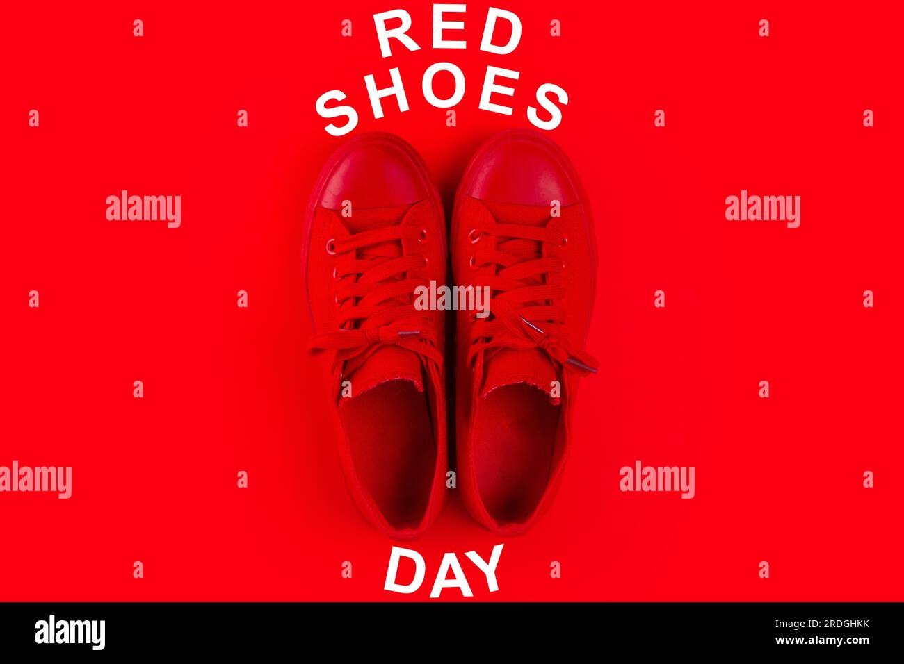 Red shoes isolated on plain red background with text: "RED SHOES DAY Stock  Photo - Alamy