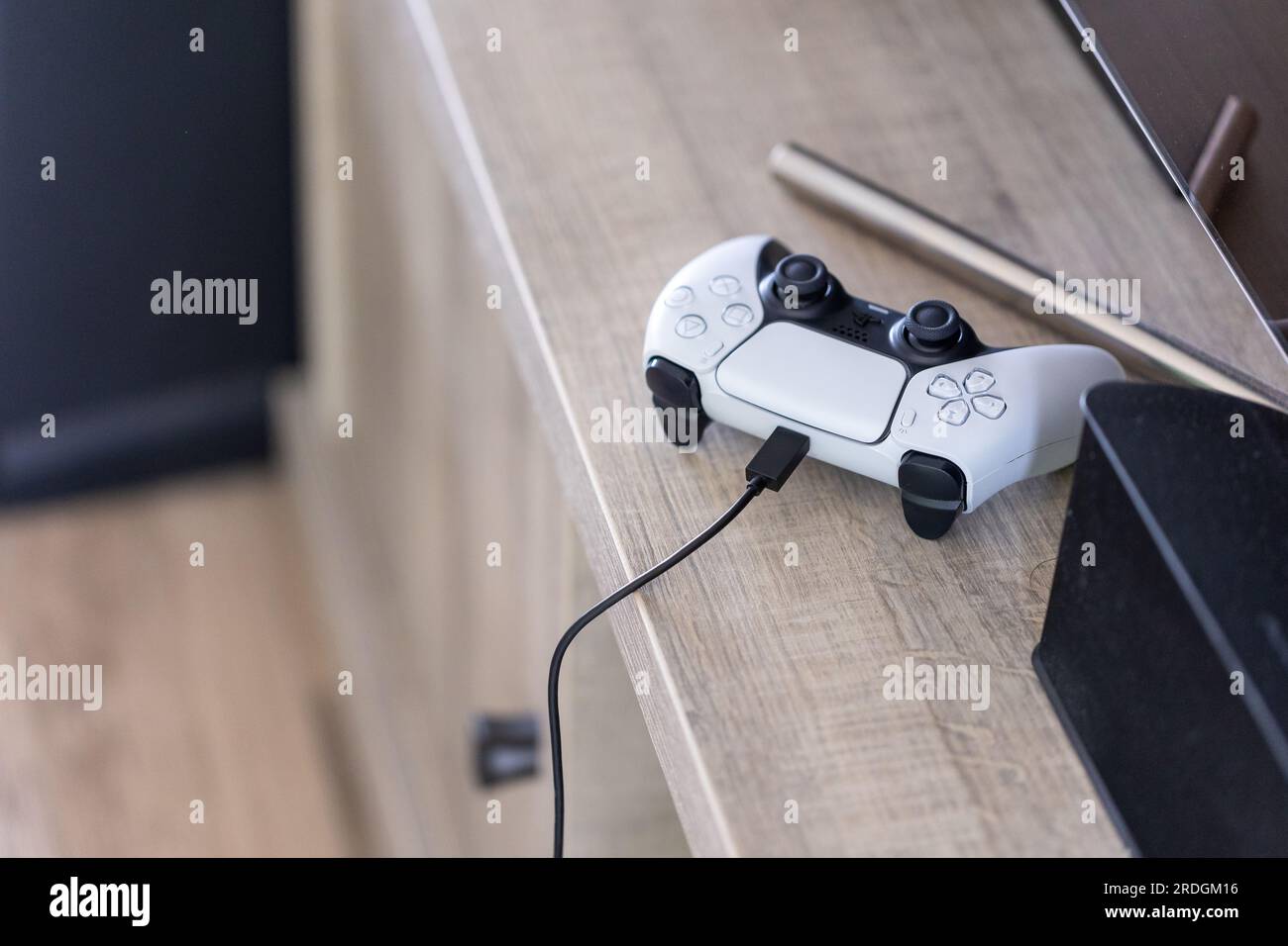Brecht, Belgium - 14 july 2023: A portrait of a standard white and black  playstation 5 game controller charging with a usb c cable in its port. The  PS Stock Photo - Alamy