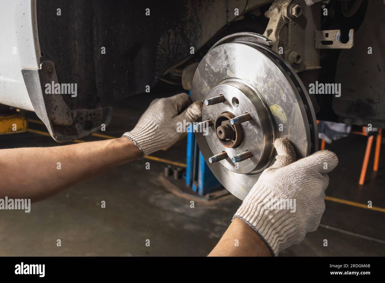 Auto mechanic is engaged in maintenance of the brake system of a car