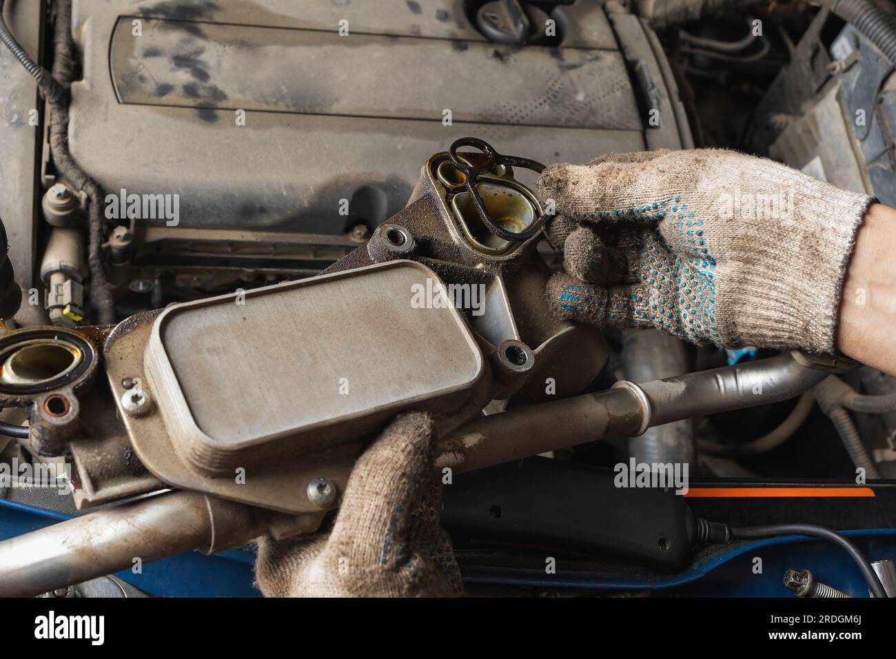 An auto mechanic changes heat exchanger gaskets for a car engine Stock Photo