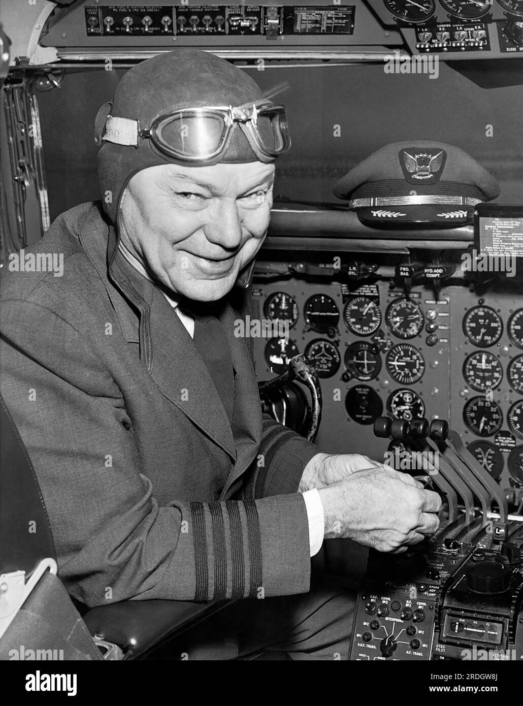 San Francisco, California: 1958 A pilot wearing old time aviation head gear and goggles in the cockpit of a modern airplane. Stock Photo