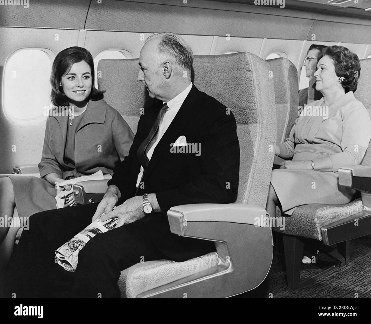 Long Beach, California:  February, 1964 Passengers sitting in the first photo of an interior mockup of Douglas Aircraft Company's new DC-9 passenger plane. First class seats on the DC-9 feature 20 inch wide seats and 3 inch armrests, along with ample leg room Stock Photo