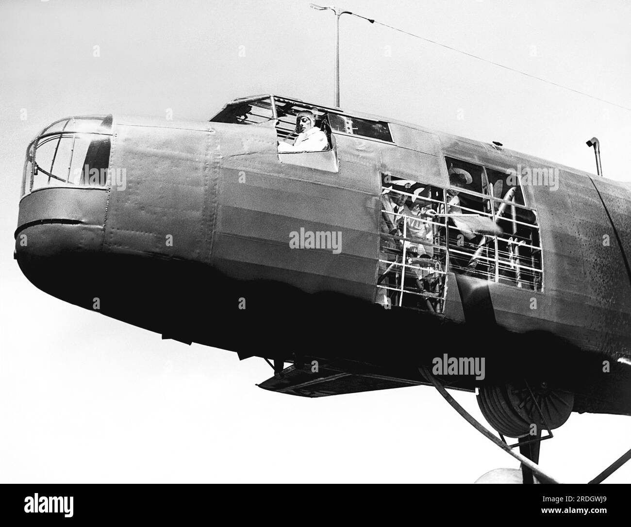 London, England:  July, 1939 A crew member of an air tanker signals to the Imperial Airways Empire flying boat that everything is ready for refueling to commence. The refueling is for the new service route crossing the Atlantic. Stock Photo