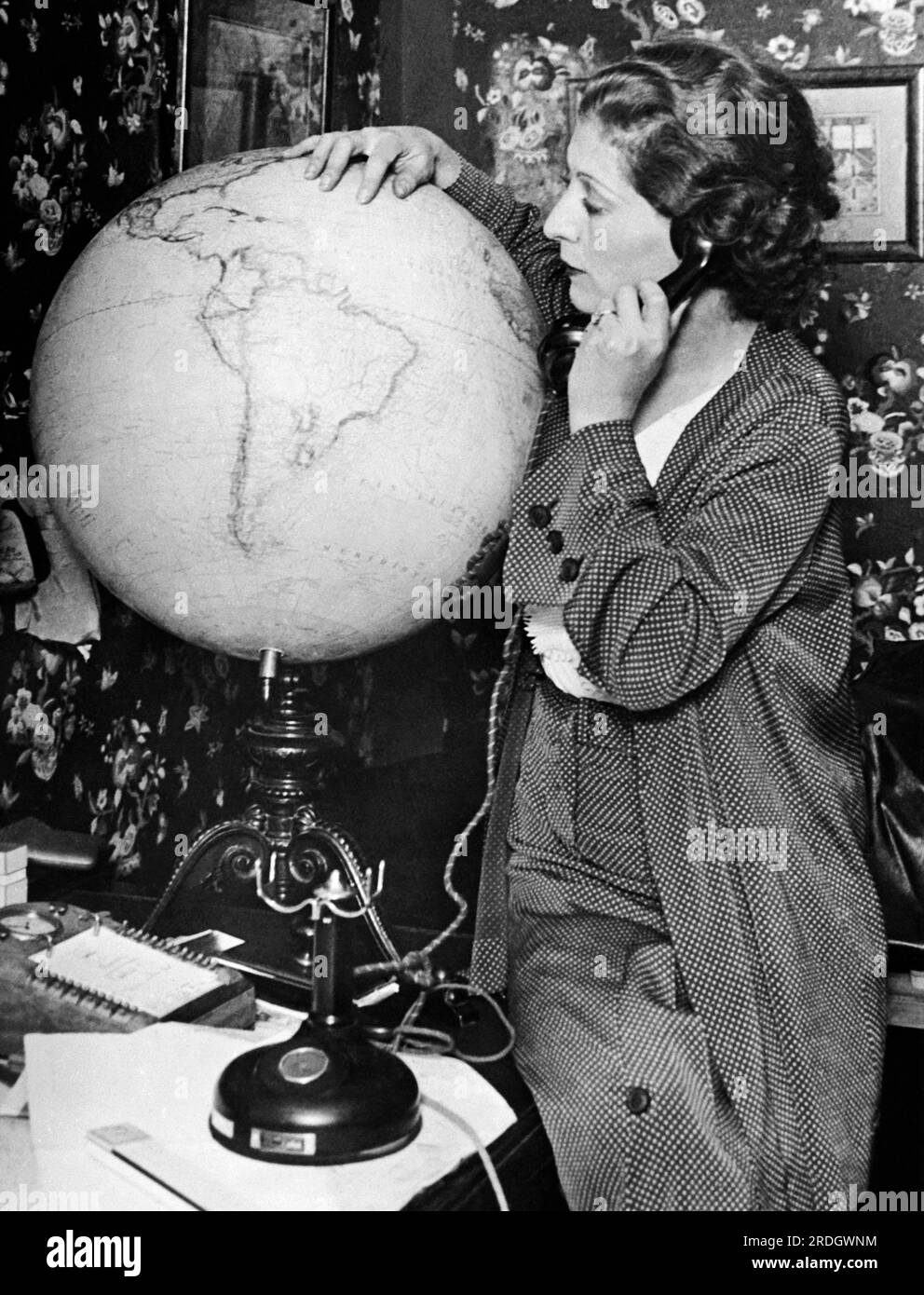 Paris, France:  September, 1930 Mme Costes, the wife of Dieudonné Costes, traces the route followed by her husband and Maurice Bellontei on their epochal flight from Paris to New York. They were the first to do so. Stock Photo