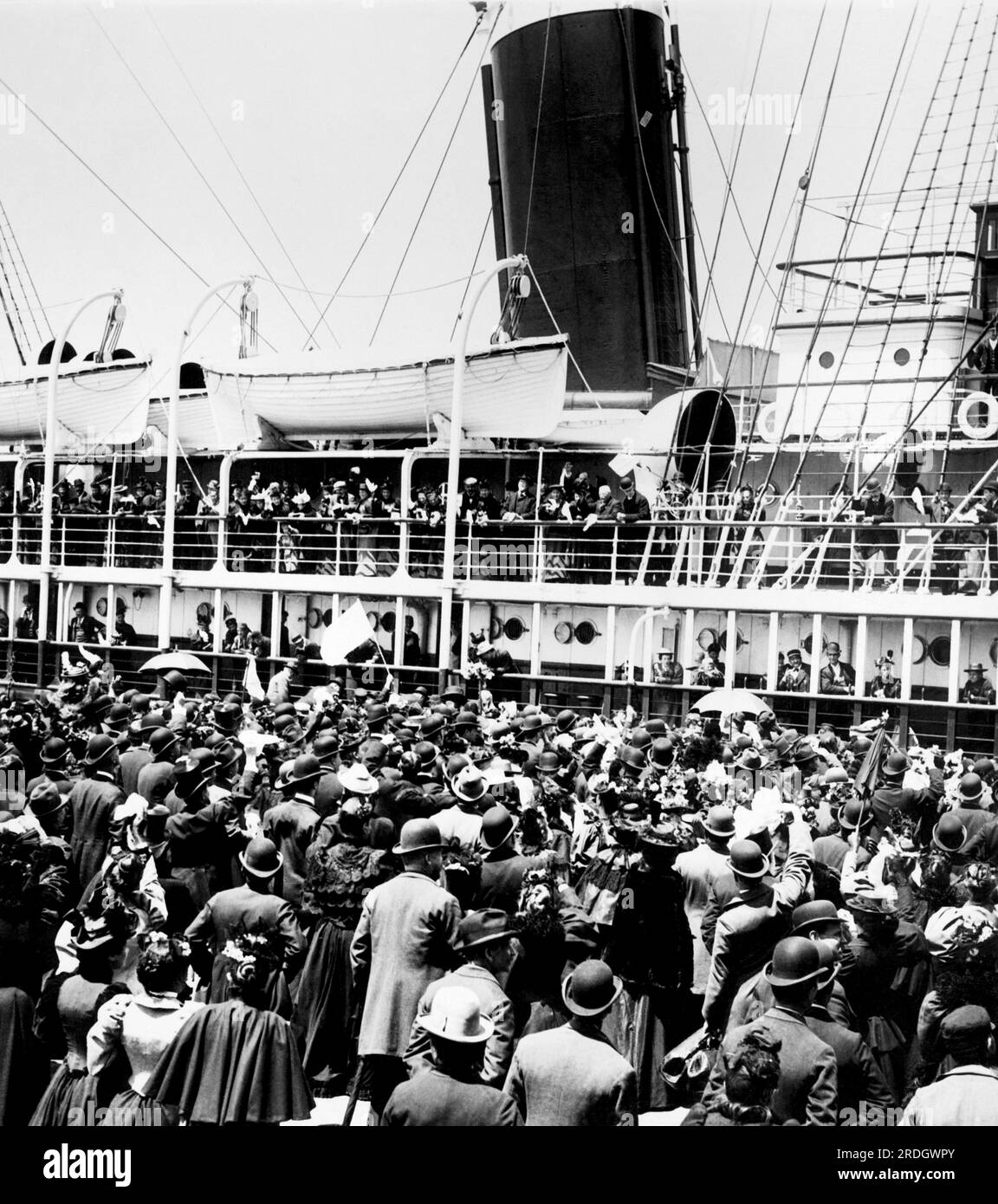 New York, New York: c. 1900 Spectators crowd the dock as a passenger ship prepares to leave for Europe. Stock Photo