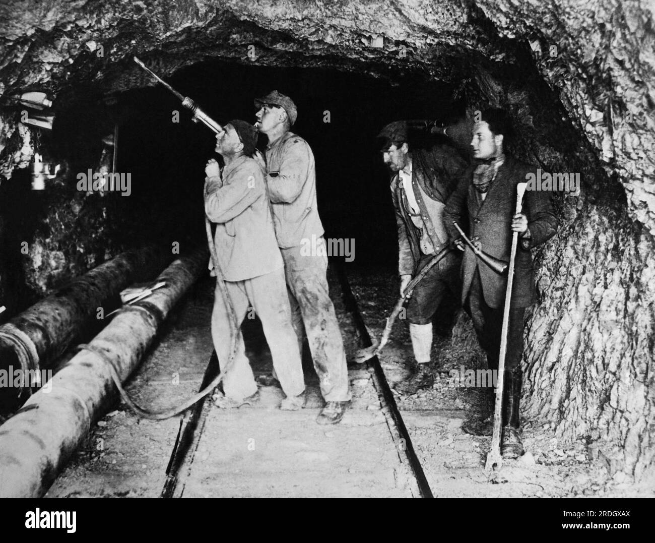 Zugspitz, Germany:  c. 1929 Railroad workers boring the tunnel through the Bavarian Zugspitz at an altitude of over 9,000 feet. The railroad will run to Eibsee. Stock Photo