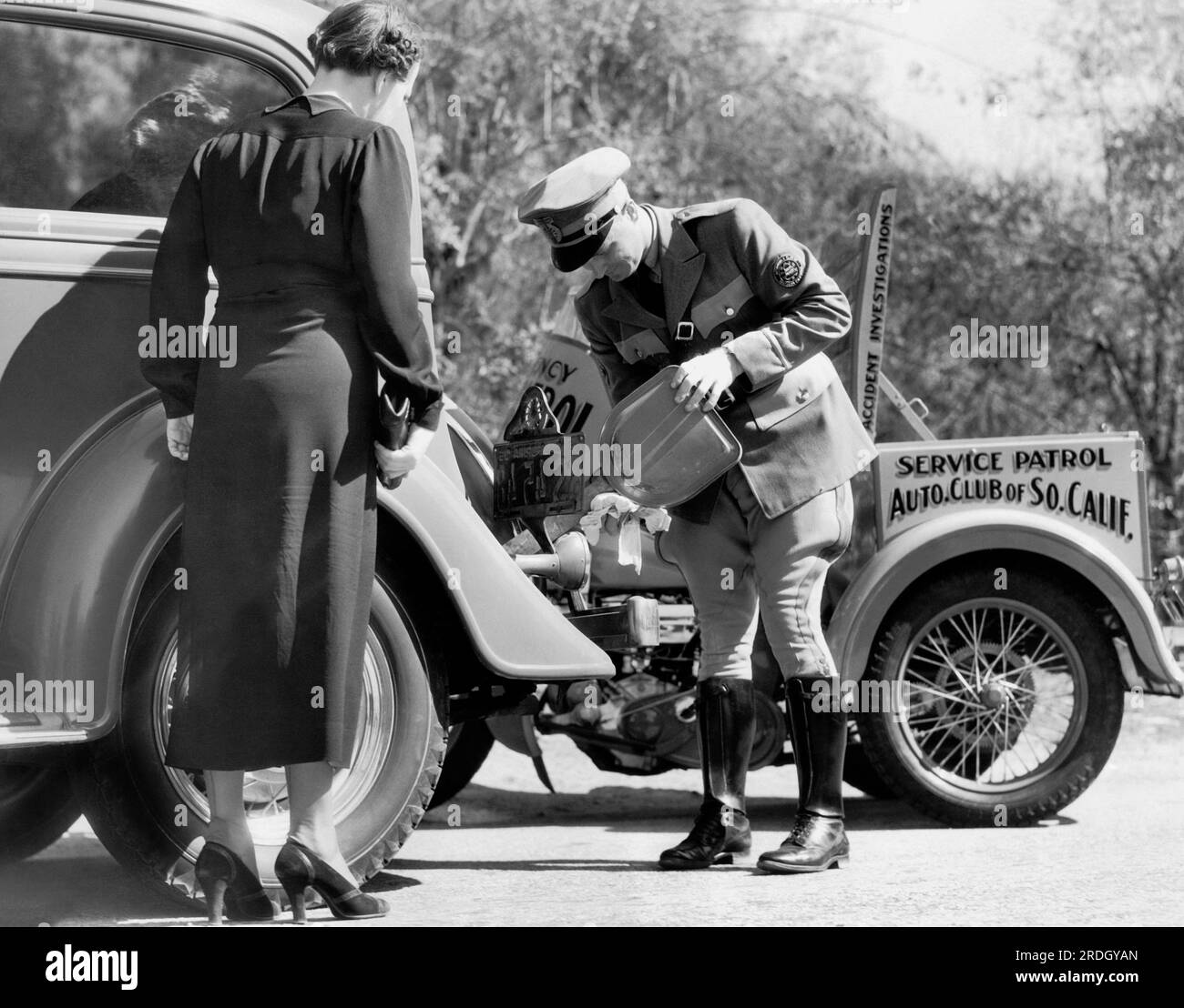 Los Angeles, California:  c..  1930 A member of the service patrol of the Automobile Club of Southern California provides help to a broken down motorist. Stock Photo
